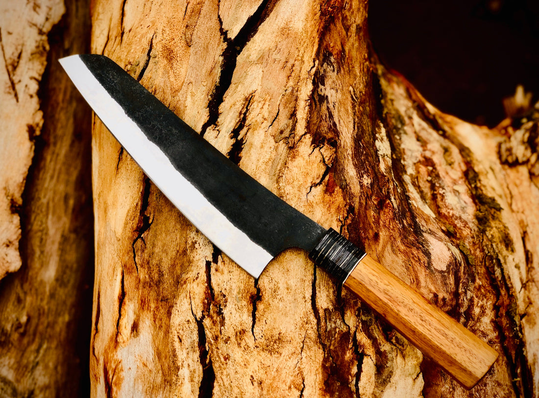 Forged chef knife showing Damascus steel pattern with wire-wrapped wood handle