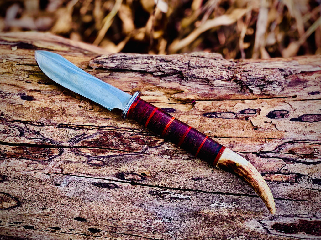 Forged hunting knife with stag antler pommel and cord-wrapped grip