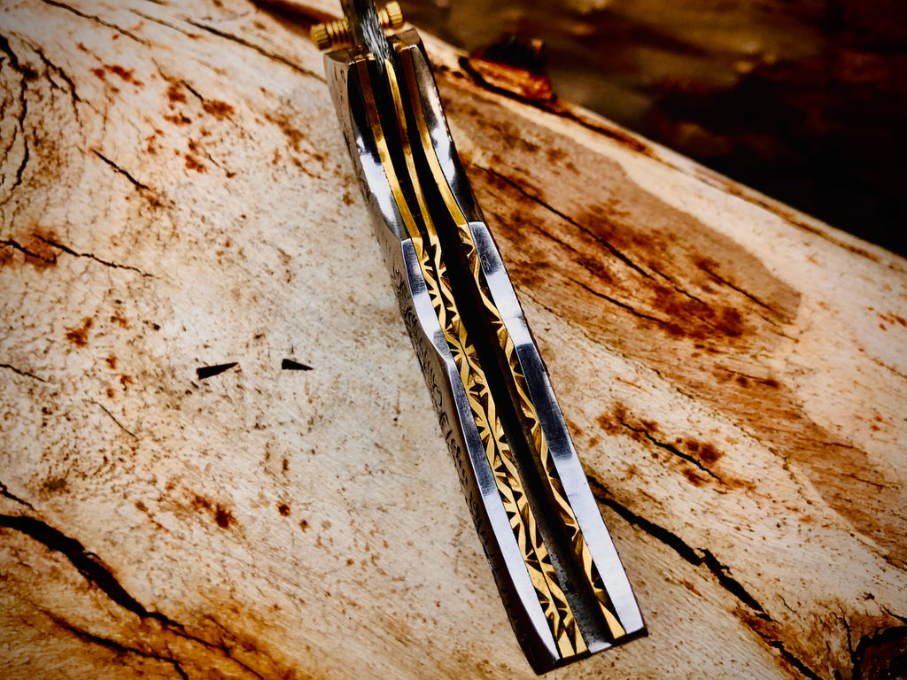 Duskrunner Damascus folding knife with engraved scroll bolsters
