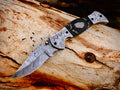 Wolfmoon Damascus folding knife with burl wood handle and engraved bolsters