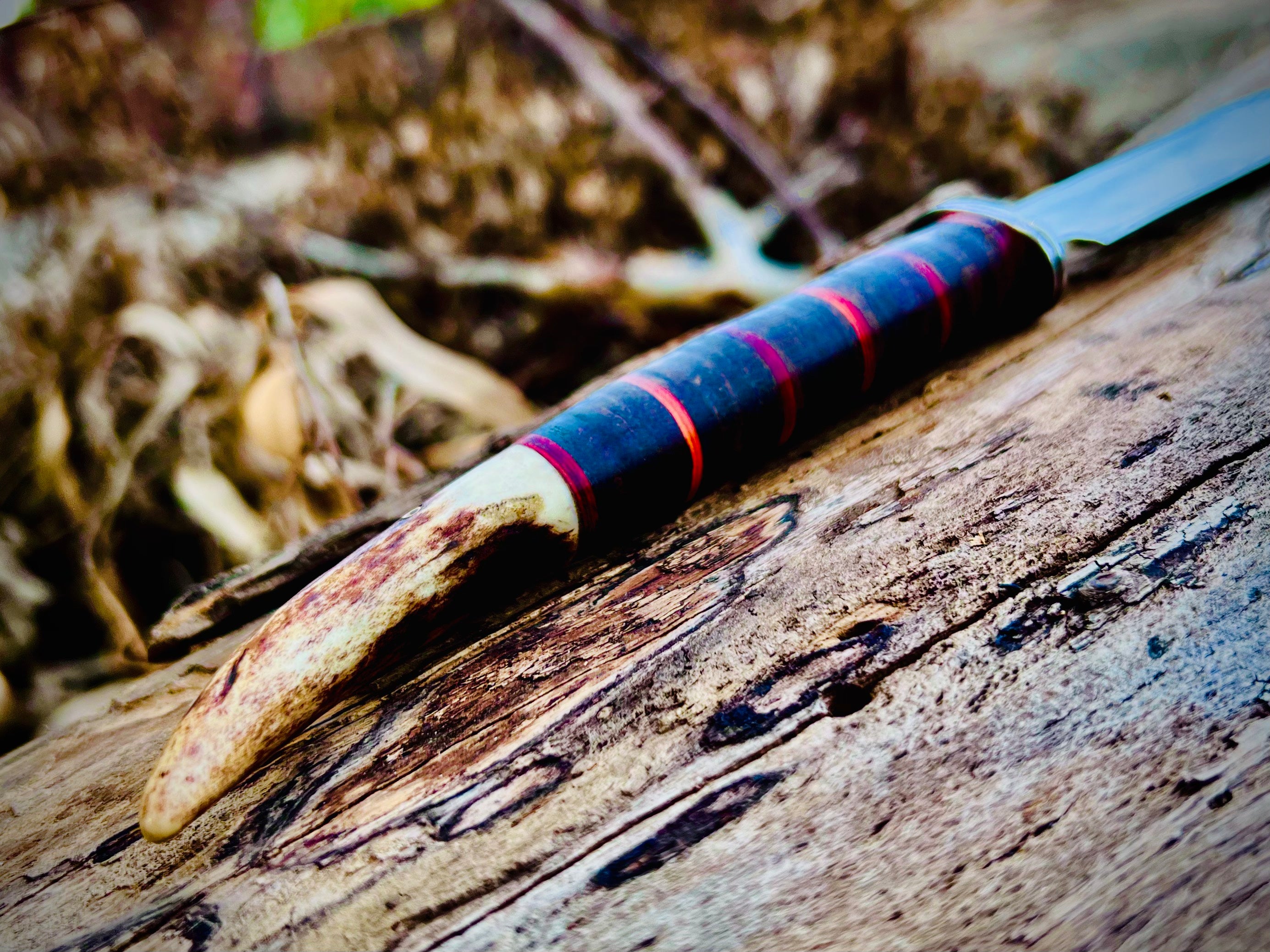 Forged hunting knife with stag antler pommel and cord-wrapped grip