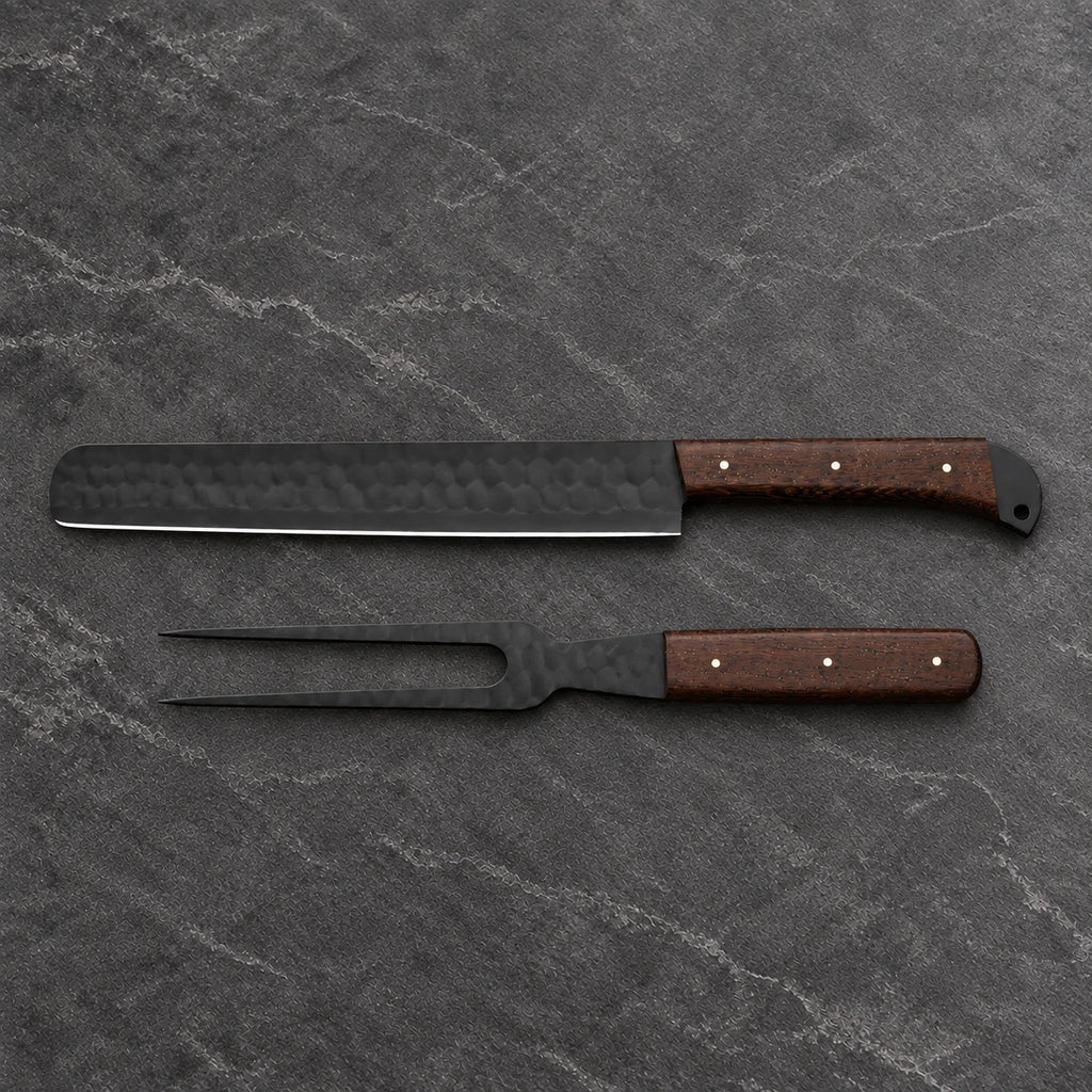 Black hammered brisket slicer and two-tine carving fork with wenge handles on dark stone