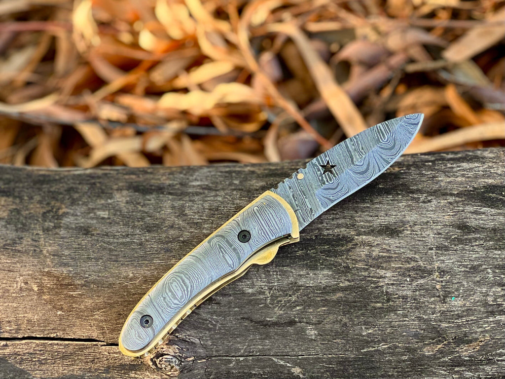 Starforge Damascus folding pocket knife with star-cutout handle