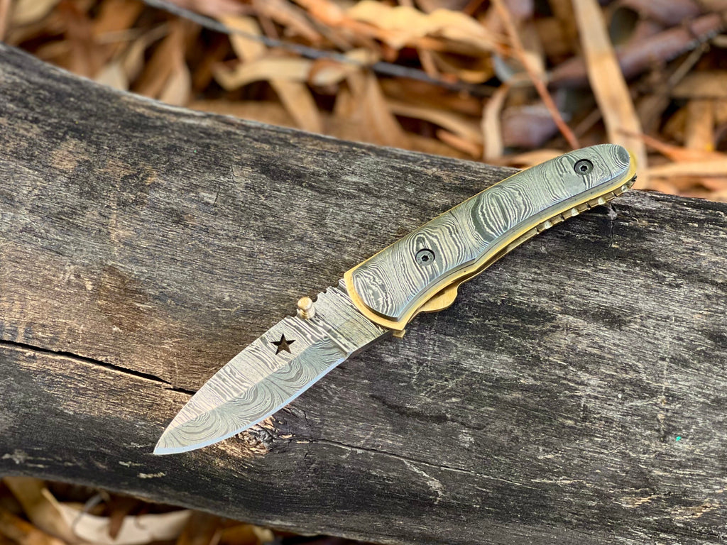 Starforge Damascus folding pocket knife with star-cutout handle