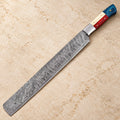 Texas flag Damascus brisket slicer knife with red, white and blue handle on a stone counter